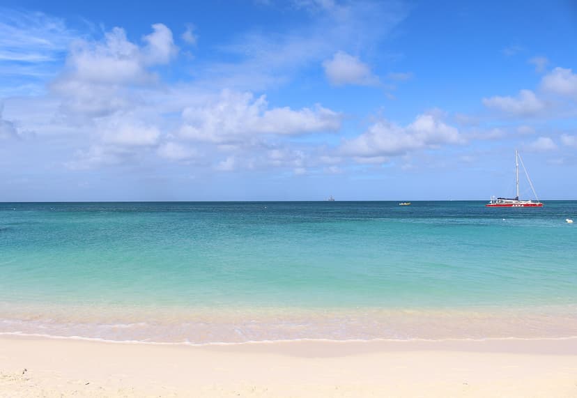 Catamaran rouge au mouillage devant la mer calme de Palm Beach, Aruba