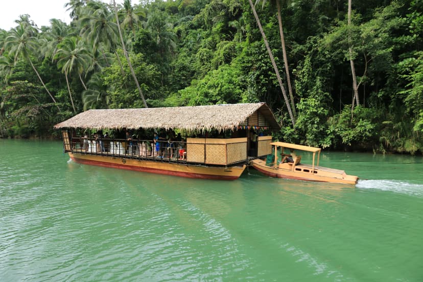 Radeau-restaurant au toit de chaume sur la rivière Loboc bordée de cocotiers, Bohol