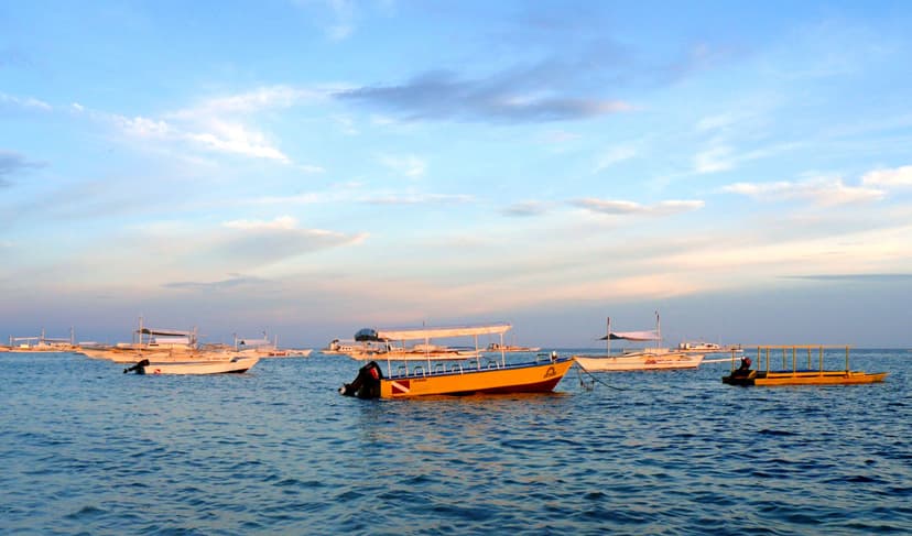 Bateaux à balancier ancrés au large d'Alona Beach à la fin du jour, île de Panglao