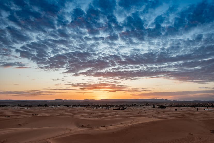 Cloud-streaked sky glowing at sunset above the Erg Chebbi dunes, Merzouga, Morocco