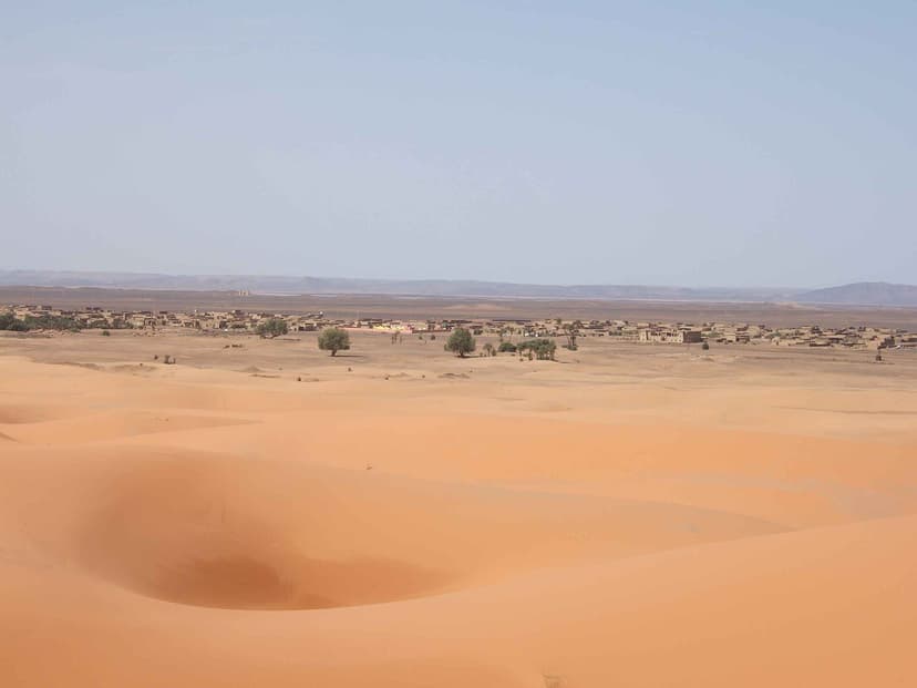 Low houses of Merzouga village seen from the first dunes of Erg Chebbi, Morocco