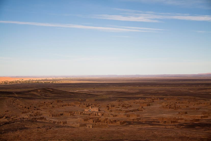 Mud-brick village on the dark stony hamada on the outskirts of Merzouga, southeastern Morocco