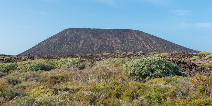 Cône volcanique dominant la végétation basse et les coulées de lave de l'île de Lobos, Fuerteventura