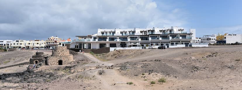 Ancien four à chaux en pierre devant les maisons blanches d'El Cotillo, côte nord-ouest de Fuerteventura