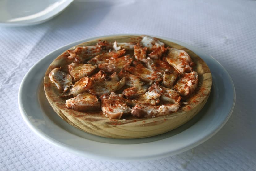 A serving of Galician-style octopus on a wooden plate
