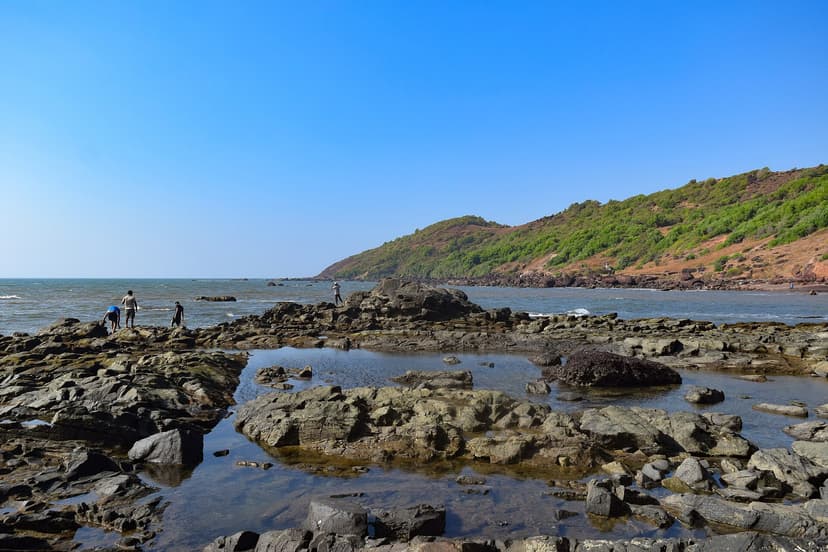 Rochers volcaniques et flaques de marée sur la plage d'Anjuna face au promontoire, nord de Goa