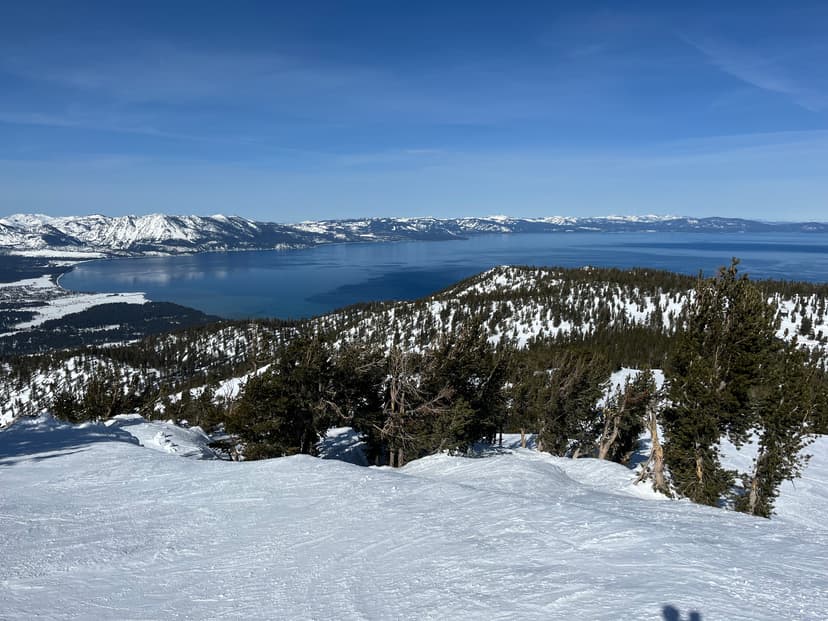Piste enneigée de la station de Heavenly dominant le lac Tahoe et les sommets de la Sierra Nevada