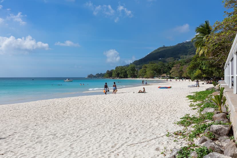Swimmers on the long white sand of Beau Vallon beach, north-west coast of Mahé